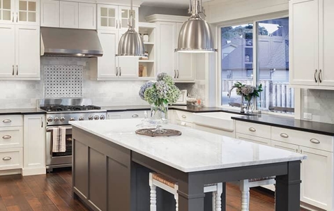 Clean white residential kitchen interior with a wooden floor.