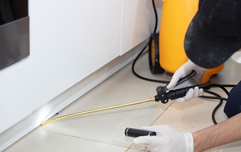 Professional Pest Control Technician treating a home.